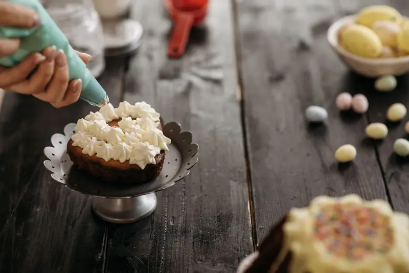 Close-up of cake decorating with icing on a cake stand, capturing the essence of homemade baking creativity