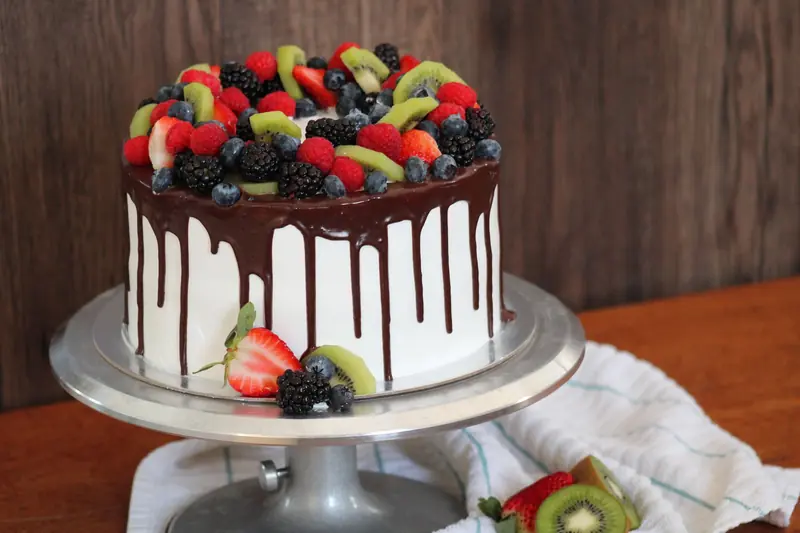 A delectable chocolate drip cake topped with fresh fruits, perfect for celebrations
