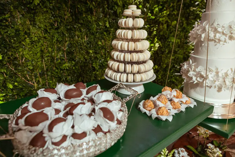 A sophisticated dessert display featuring a macaron tower, truffles, and a tiered wedding cake