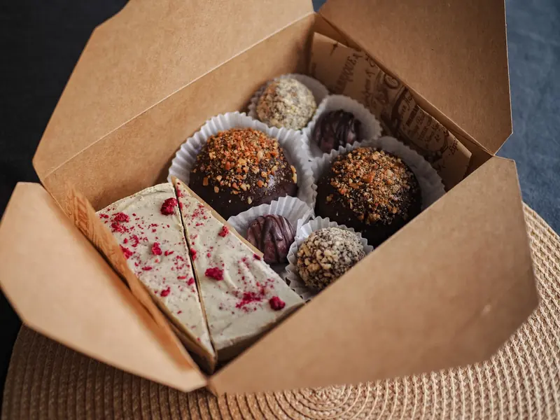 Delicious assortment of gourmet truffles and cake slices elegantly packed in a cardboard box