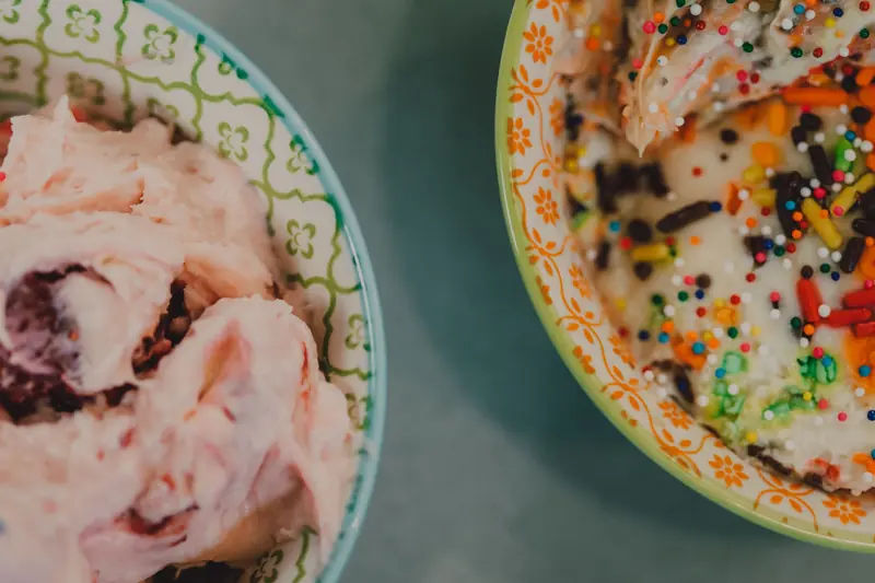 Close-up of colorful ice cream with sprinkles in ceramic bowls, top view