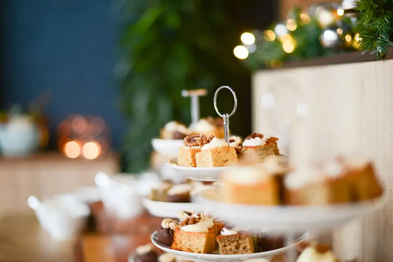 Close-up of festive cake assortment on tiered stand with bokeh lights