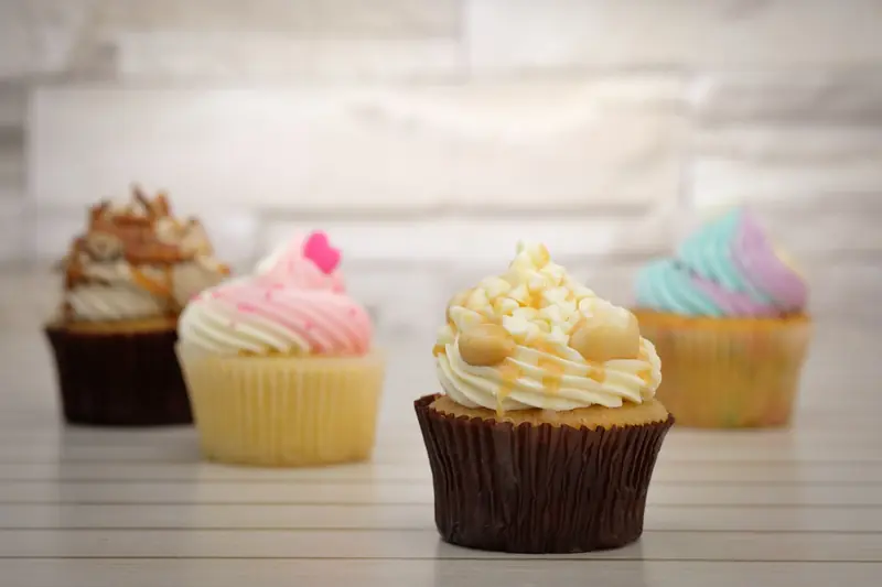 Deliciously decorated cupcakes with colorful frosting displayed on a wooden surface, perfect for dessert lovers