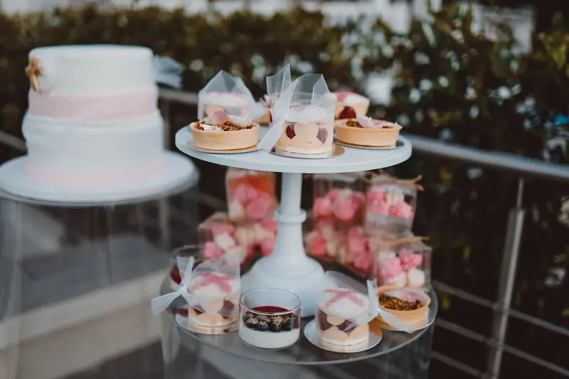 Elegant outdoor display of various desserts and a cake on a two-tier stand